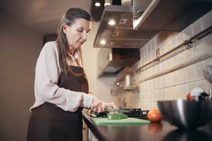 Woman preparing a healthy meal with fresh vegetables in her home kitchen